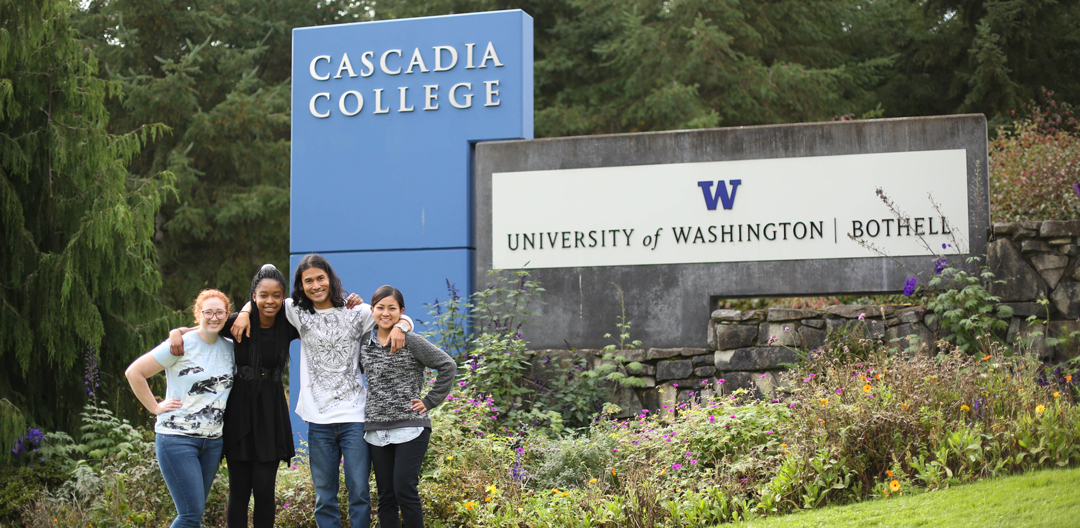 Sign at the Cascadia College and University of Washington Bothell campus entrance with flowers and landscaping in foreground